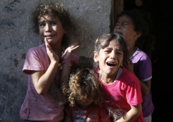 Young relatives of four boys, all from the Bakr family, killed during Israeli shelling, cry during their funeral in Gaza City, on July 16, 2014. Four children were killed and several injured at a beach in Gaza City medics said, in Israeli shelling witnessed by AFP journalists. The strikes appeared to be the result of shelling by the Israeli navy against an area with small shacks used by fishermen. The deaths raised the overall toll in nine days of violence in Gaza to 213. AFP PHOTO / MOHAMMED ABEDMOHAMMED ABED/AFP/Getty Images